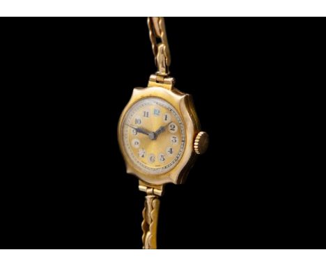 A 9ct lady's manual wind bracelet wristwatch. The 16mm gold and silvered dial with black Arabic numerals, 15 jewel movement, 