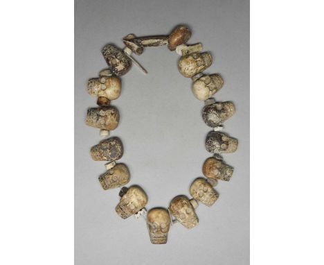 An Aztec skull necklaceMexico, circa 1200 - 1400 ADshell, the fourteen carved skull beads drilled through the sides and backs