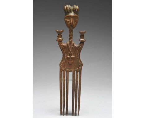 An Akan comb Ghana with a carved head surmount having a braided coiffure with black staining, and with a long ringed neck and