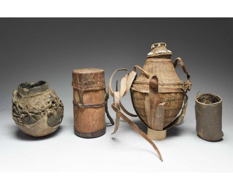 Two Turkana hide apronsKenyawith metal beads,70cm and 82cm long,five wooden footed cups, the largest, 17cm high and inscribed