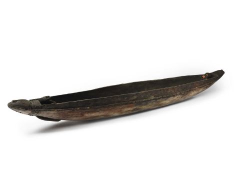 A Papua New Guinea woman's canoeMelanesiathe prows with crocodile heads and standing curved male ancestor figures, with a car