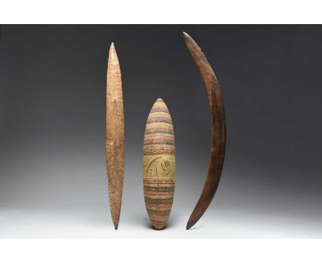 An Aboriginal narrow shieldAustraliawith incised geometric decoration and with an integral handle,77cm long,another shield wi