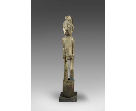 A Dayak hampatong figureIndonesiathe standing male with a petal and ropework headdress,141cm high, on a base.ProvenanceDr Lau