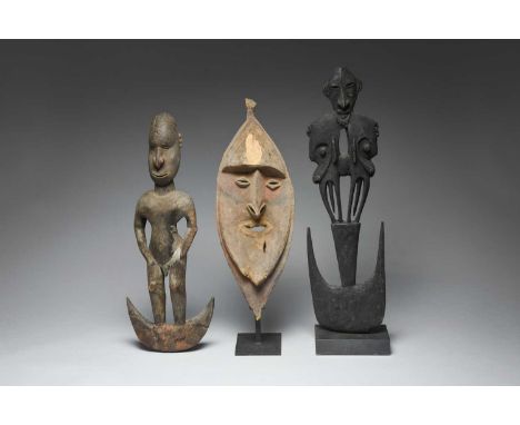 An Iatmul suspension hookPapua New Guineawith a standing male figure having inset cowrie shell eyes and a pierced septum,59cm