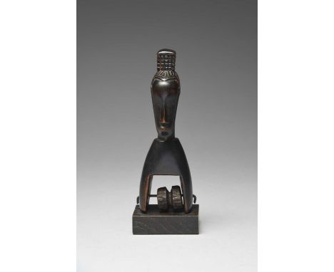 A Guro heddle pulleyIvory Coastwith a long mask and pony tail, the block top pierced for attachment, with a reel, 17cm high, 