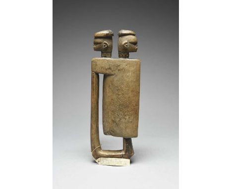 An Ibo anthropomorphic slit drum Nigeria with two carved heads to the top, with cap like coiffures, one with an arrow symbol 