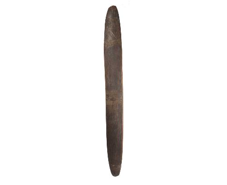 An Aboriginal narrow shieldAustraliaslightly curved with carved grooved linear decoration to both sides, the integral handle 
