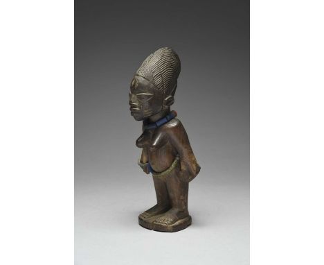 A Yoruba female Ibeji figure by Salakatu AyoAbeokuta, Nigeriawith a fine layered and tied coiffure, wearing glass beads and a