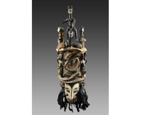 An Igbo mask mgbedikeWestern Isuama, Nigeria with open eyes and carved teeth, with a cloth back having applied bands of seed 