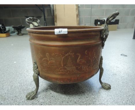 A large vintage copper bodied planter with three footed brass base and twin handle with oriental imagery 