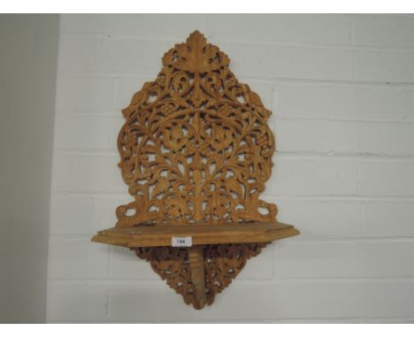 A wall hanging shelf in a Bohemian style of middle eastern carved wood