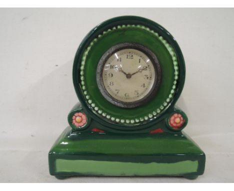 A vintage clock with green glaze ceramic body in a French style