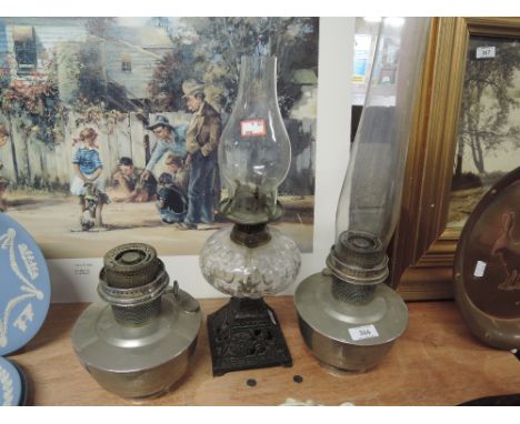 A selection of vintage oil burning lamps including T Rowatt cast body and glass cut well lamp 