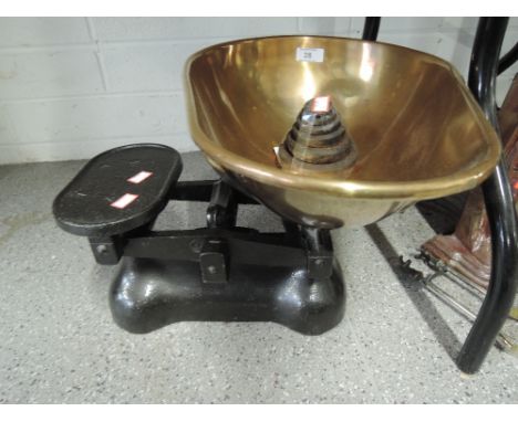 A traditional vintage balance scale set with cast body and large copper dish
