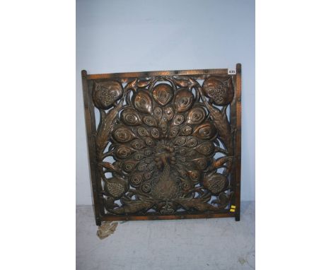 A copper Art and Crafts style pierced panel, decorated with a peacock and stylised flowers. 61cm x 61cm 