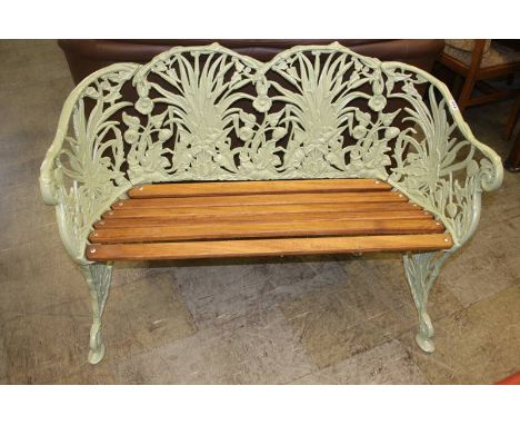 An apple green ornate two seater garden bench, 118cm wide