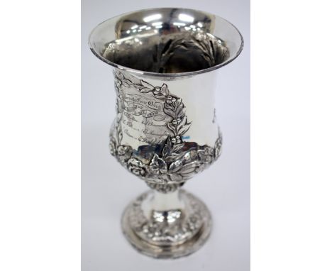 A VICTORIAN SILVER TROPHY CUP with embossed floral swag and laurel wreath decoration, standing on circular spreading base wit