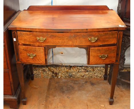 A GEORGIAN MAHOGANY BOW FRONTED SIDE TABLE, the single drawer over a recess flanked by drawers to either side and all standin