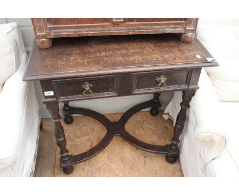 AN OAK SIDE TABLE with single frieze drawer and standing on turned tapering legs united by a shaped stretcher