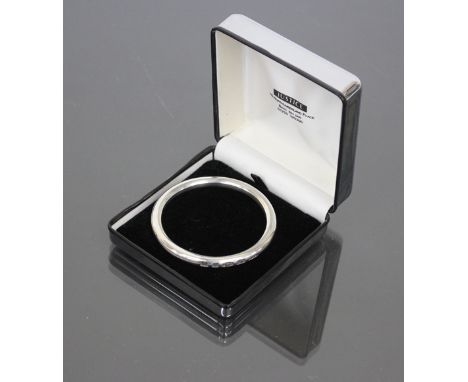A HEAVY SILVER BANGLE with makers mark of SGC, 6.8cm diameter 
