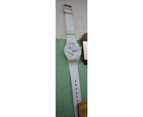 A LARGE WALL HANGING SWATCH WATCH with white plastic strap, white dial and decorated with geometric coloured shaped, the dial