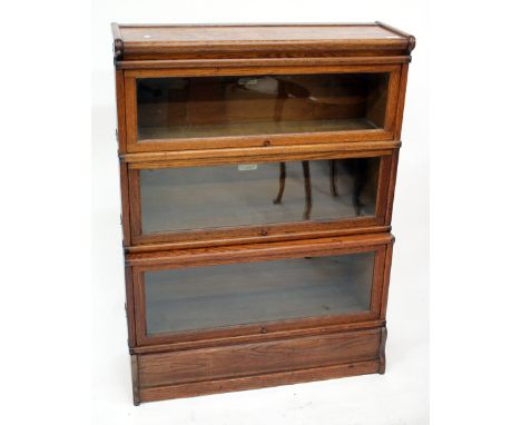 AN OAK GLOBE WERNICKE THREE SECTIONED BOOKCASE with glazed up and over doors, 69cm wide