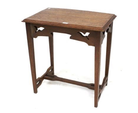 An oak Arts &amp; Crafts side table with pierced decoration. Raised on square tapering supports united by a fork H stretcher.