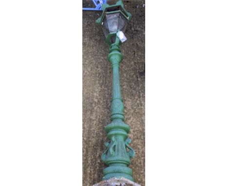 A 20th century green painted cast metal outside lamp post. With glazed panelling surrounding the light, approximately 190cm h