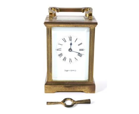 A contemporary brass cased Mappin and Webb carriage clock. The enamel dial with Roman numerals denoting hours, with bevelled 