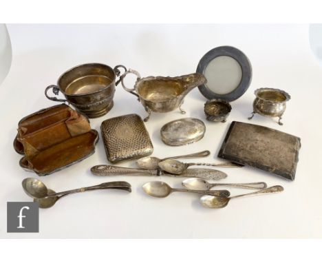 A parcel lot of assorted hallmarked silver items to include a sauce boat, two cigarette cases, and evening purse and flat war