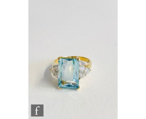 An 18ct hallmarked aquamarine and diamond ring, central emerald cut aquamarine, length 14mm, flanked by three brilliant cut d