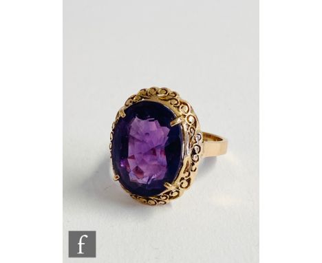 A 14ct single stone amethyst ring, claw set oval stone to a pierced border and plain shoulders, weight 7g, ring size O. 