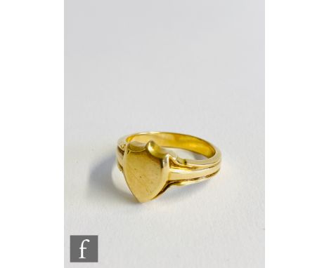 An 18ct hallmarked gentleman's signet ring with shield shaped head and ribbed shank, total weight 12.3g, ring size U, London 