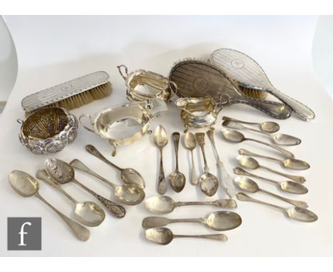 A small parcel lot of assorted silver to include a cream and sugar, sauce boat, flatware and a part brush set, various styles