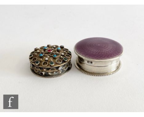 A hallmarked silver circular rouge pot with mauve enamel decoration to cover, diameter 4cm, with a similar silver stone set e