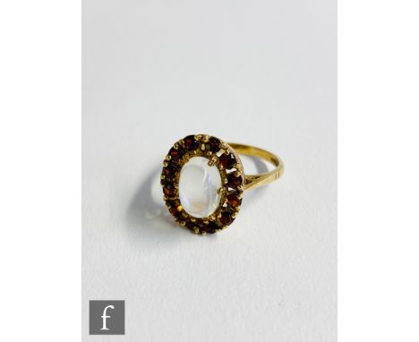 A 9ct hallmarked moonstone and garnet cluster ring, central moonstone within garnet surround, weight 3.2g, ring size N 1/2, B