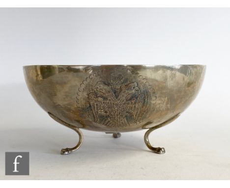 A low grade silver circular bowl with embossed double headed eagle and a lion, all raised on three claw feet, diameter 19cm, 