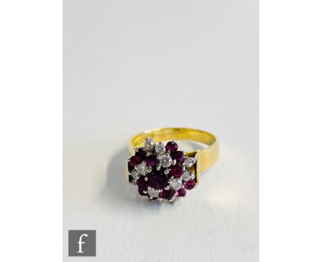 An 18ct ruby and diamond cluster ring, the circular head with alternate rows of rubies and diamonds radiating from a central 