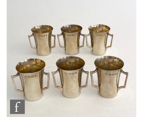 A set of six hallmarked silver three handled shot cups of plain from, heights 4.5cm, Birmingham 1910, The Alexander Clark Man