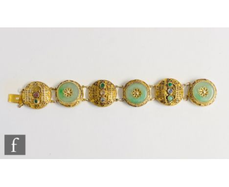 An early 20th Century Chinese silver gilt six circular panelled bracelet decorated with three apple green jadite panel spaced