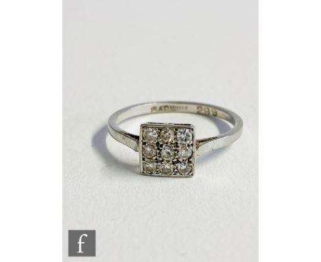 An early 20th Century platinum diamond nine stone floodlight ring, transitional cut stones to plain shoulders, weight 2.2g, r