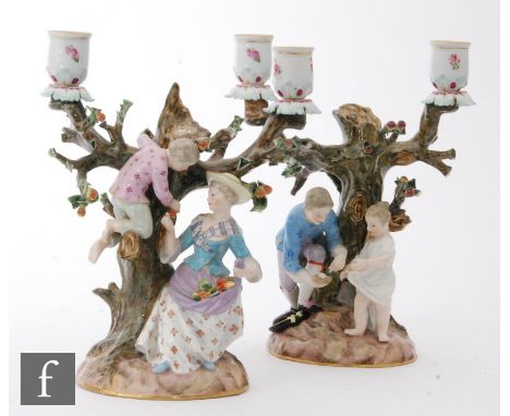 A pair of late 19th to early 20th Century Meissen twin branch candlesticks, the first with a lady and her little boy picking 
