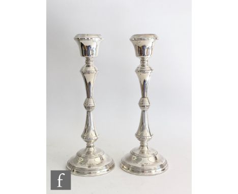 A pair of hallmarked silver candlesticks, circular bases with reeded details below conforming knop column and circular sconce