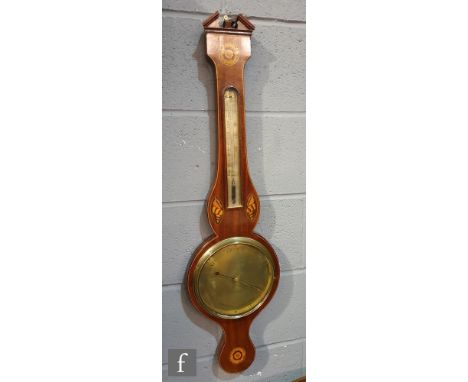 An early 19th Century mahogany wheel barometer with inlaid floral and shell paterae, with an architectural pediment above the