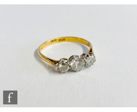 A mid 20th Century 18ct diamond three stone ring, claw set brilliant cut stones to knife edged shoulders, center stone approx