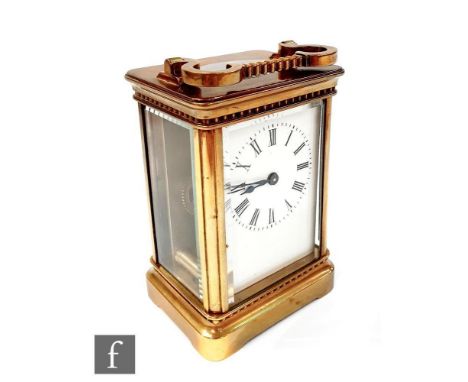 A 19th Century French brass carriage clock with white enameled dial in beveled glazed case and bracket plinth, height 12cm. 