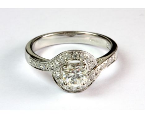 An 18ct white gold ring set with a centre brilliant cut diamond (approx. 0.56ct) surrounded by diamonds and diamond set shoul