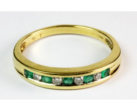 An 18ct yellow gold diamond and emerald half eternity ring (R.5).