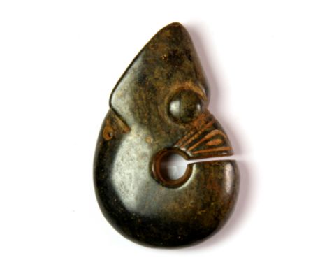 A Chinese archaic form carved dark green jade/hardstone amulet of a coiled dragon, H. 8cm.