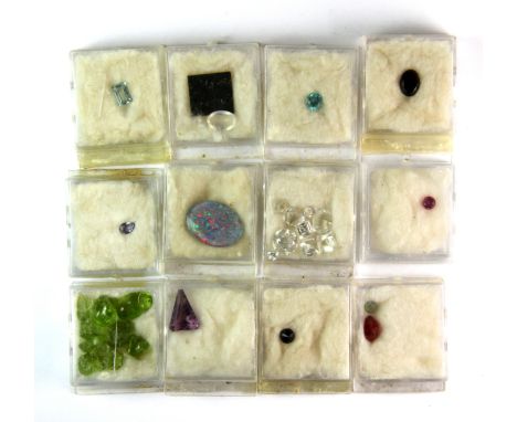 A quantity of mixed un-mounted gemstones and others, including a ruby, tanzanite, opal triplet, rough peridots, etc.